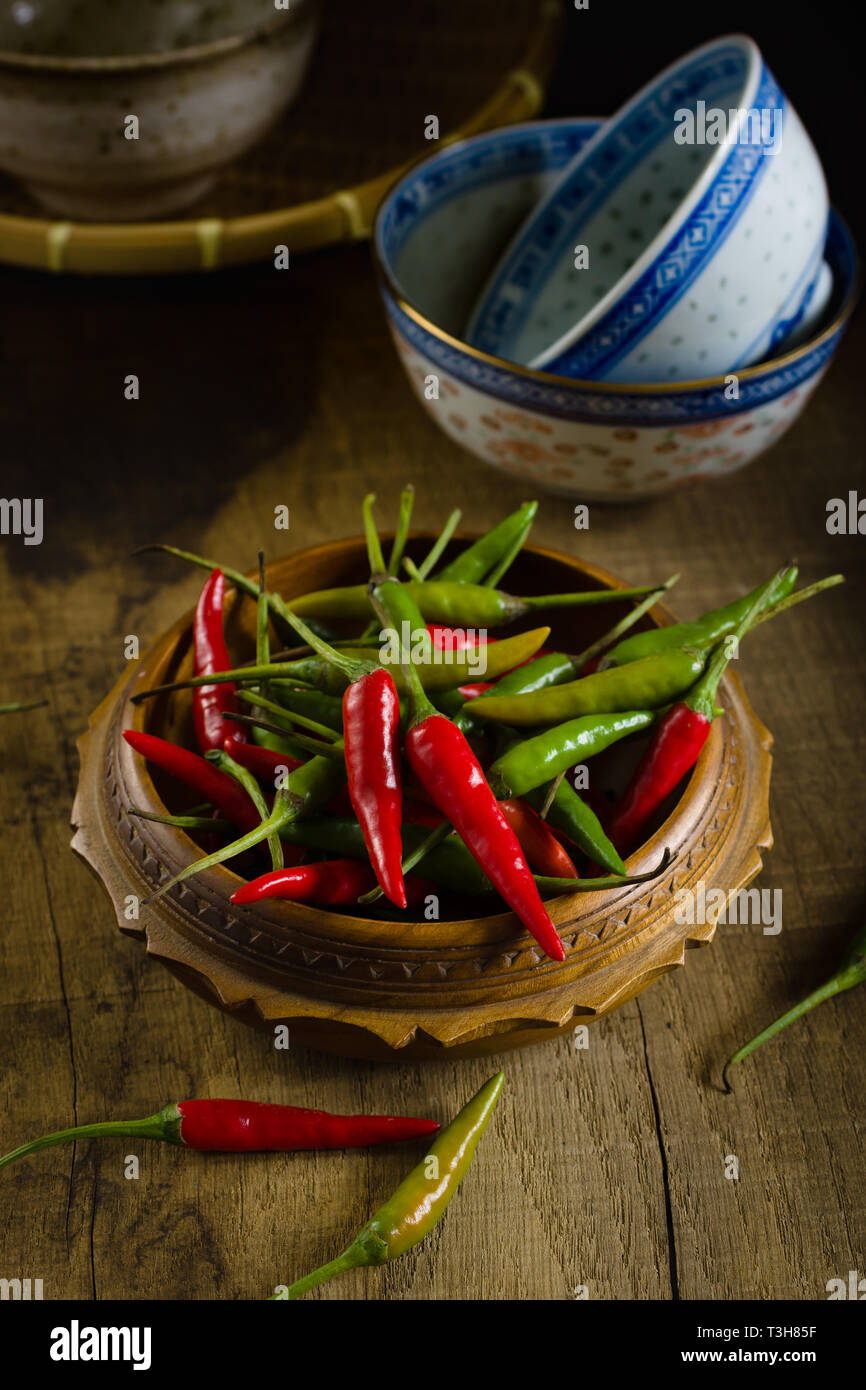 Thai red and green chilis or Prik chee fah also sometimes known as Birds Eye chile pepper fiery peppers rated at 50,000 to 100,000 scoville units Stock Photo