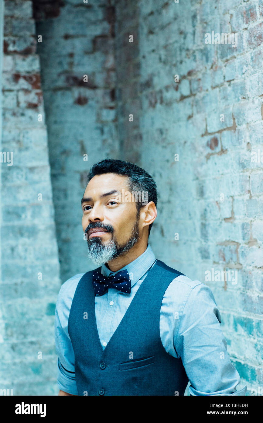Portrait of a successful mature man with silver beard in vest and bow tie  looking up Stock Photo - Alamy