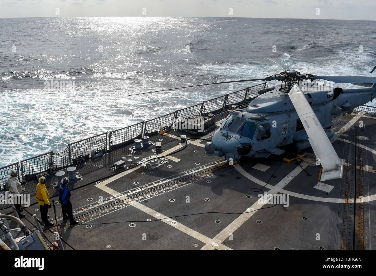 190404-N-UM706-0043 ATLANTIC OCEAN (April 4, 2019) Sailors communicate with the pilots in an MH-60R Sea Hawk Helicopter assigned to the “Grandmasters” of Helicopter Maritime Strike Squadron (HSM) 46 during flight quarters on the flight deck aboard the Arleigh Burke-class guided-missile destroyer Nitze (DDG 94). Nitze is underway as part of Abraham Lincoln Carrier Strike Group (ABECSG) deployment in support of maritime security cooperation efforts in the U.S. 5th, 6th and 7th Fleet areas of responsibility. With Abraham Lincoln as the flagship, deployed strike group assets include staffs, ships  Stock Photo