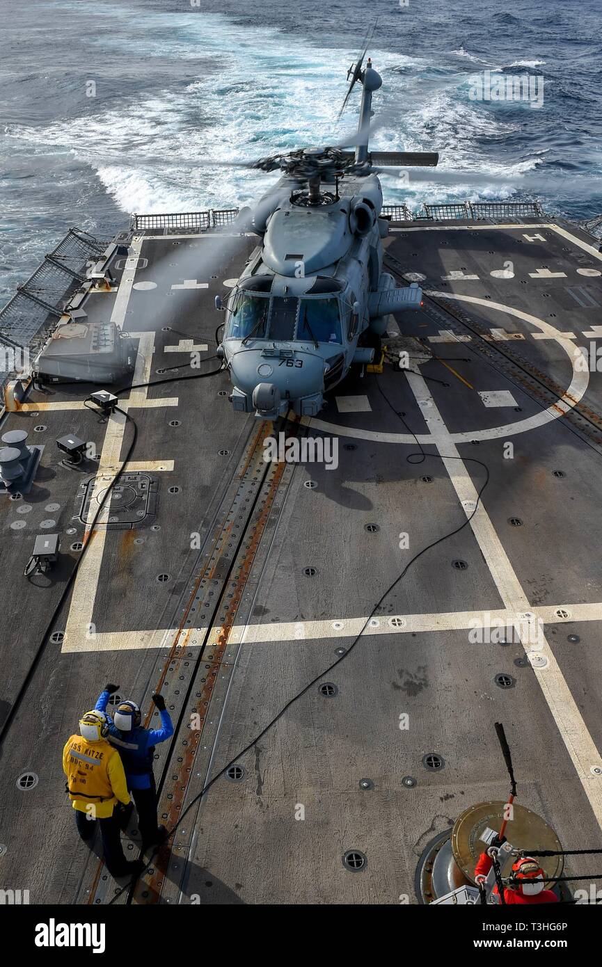 190404-N-UM706-0065 ATLANTIC OCEAN (April 4, 2019) Sailors communicate with the pilots in an MH-60R Sea Hawk Helicopter assigned to the “Grandmasters” of Helicopter Maritime Strike Squadron (HSM) 46 during flight quarters on the flight deck aboard the Arleigh Burke-class guided-missile destroyer Nitze (DDG 94). Nitze is underway as part of Abraham Lincoln Carrier Strike Group (ABECSG) deployment in support of maritime security cooperation efforts in the U.S. 5th, 6th and 7th Fleet areas of responsibility. With Abraham Lincoln as the flagship, deployed strike group assets include staffs, ships  Stock Photo