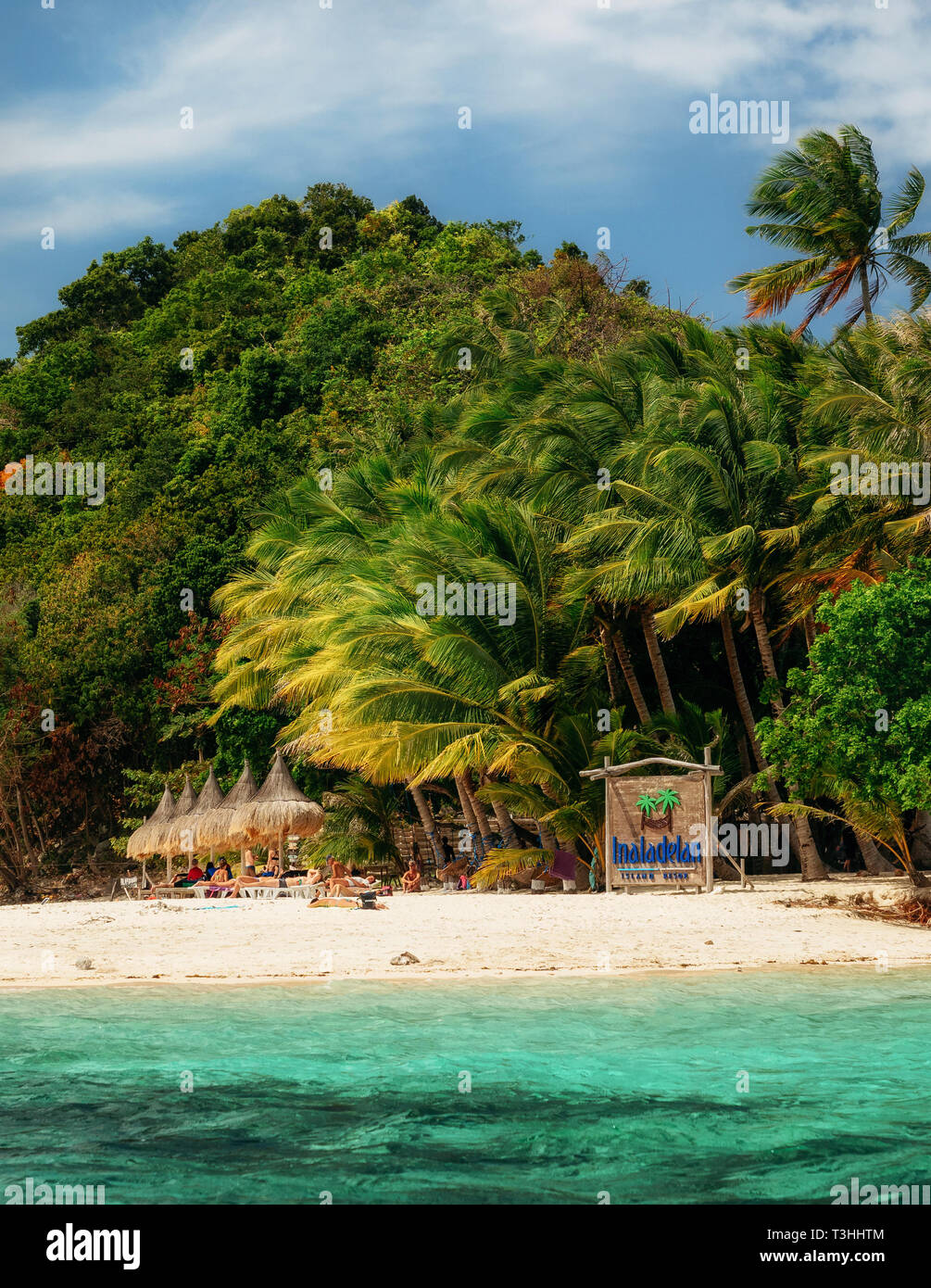 German island, San Vicente, Philippines - February 4, 2019: Sandy beach with turquoise water and green palm trees on tropical island Stock Photo
