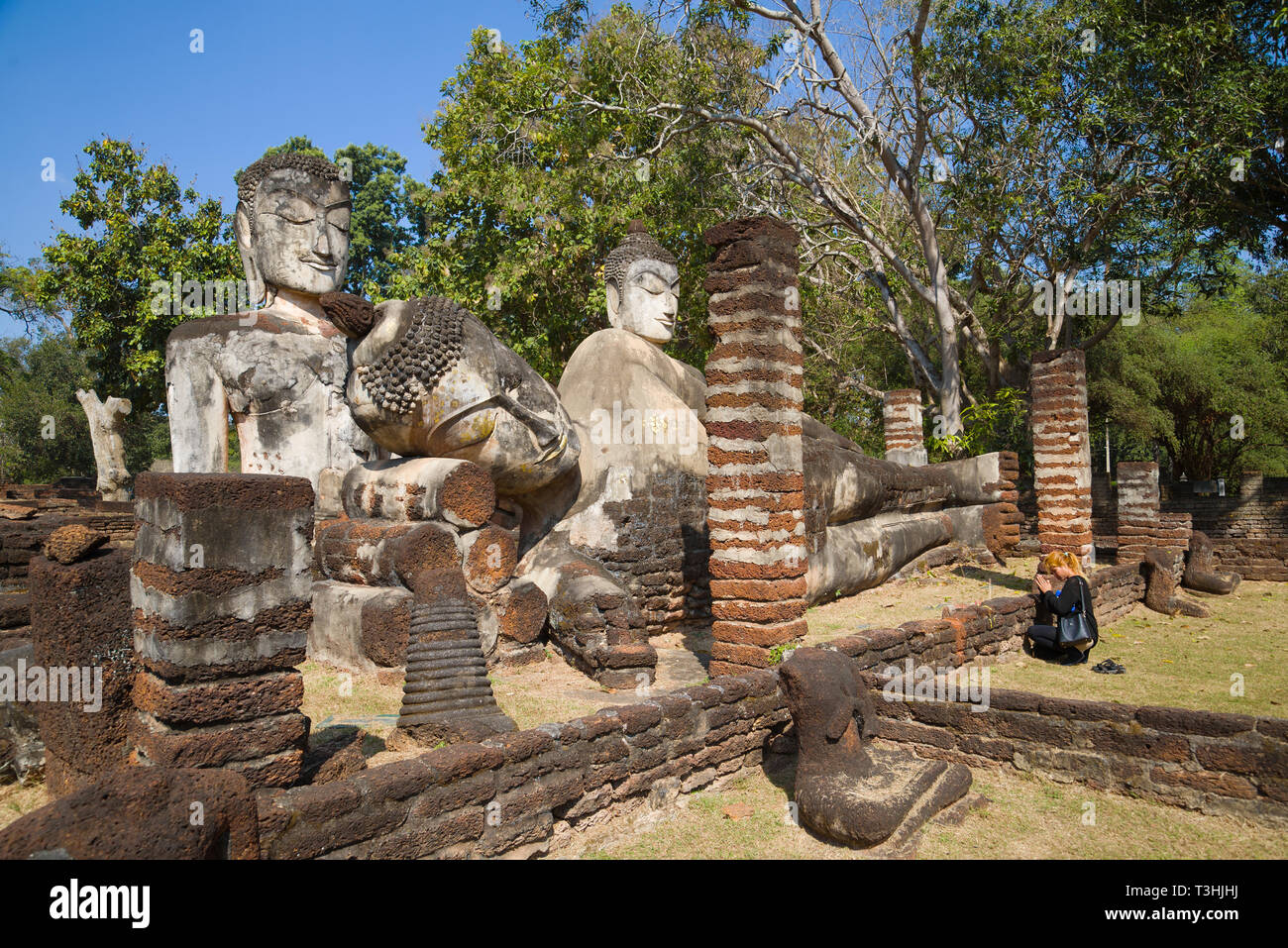 KAMPHAENG PHET, THAILAND - DECEMBER 30, 2016: Prayer at the ancient Buddhist statues. The ruins the Buddhist  temple of Wat Phra Kaeo Stock Photo