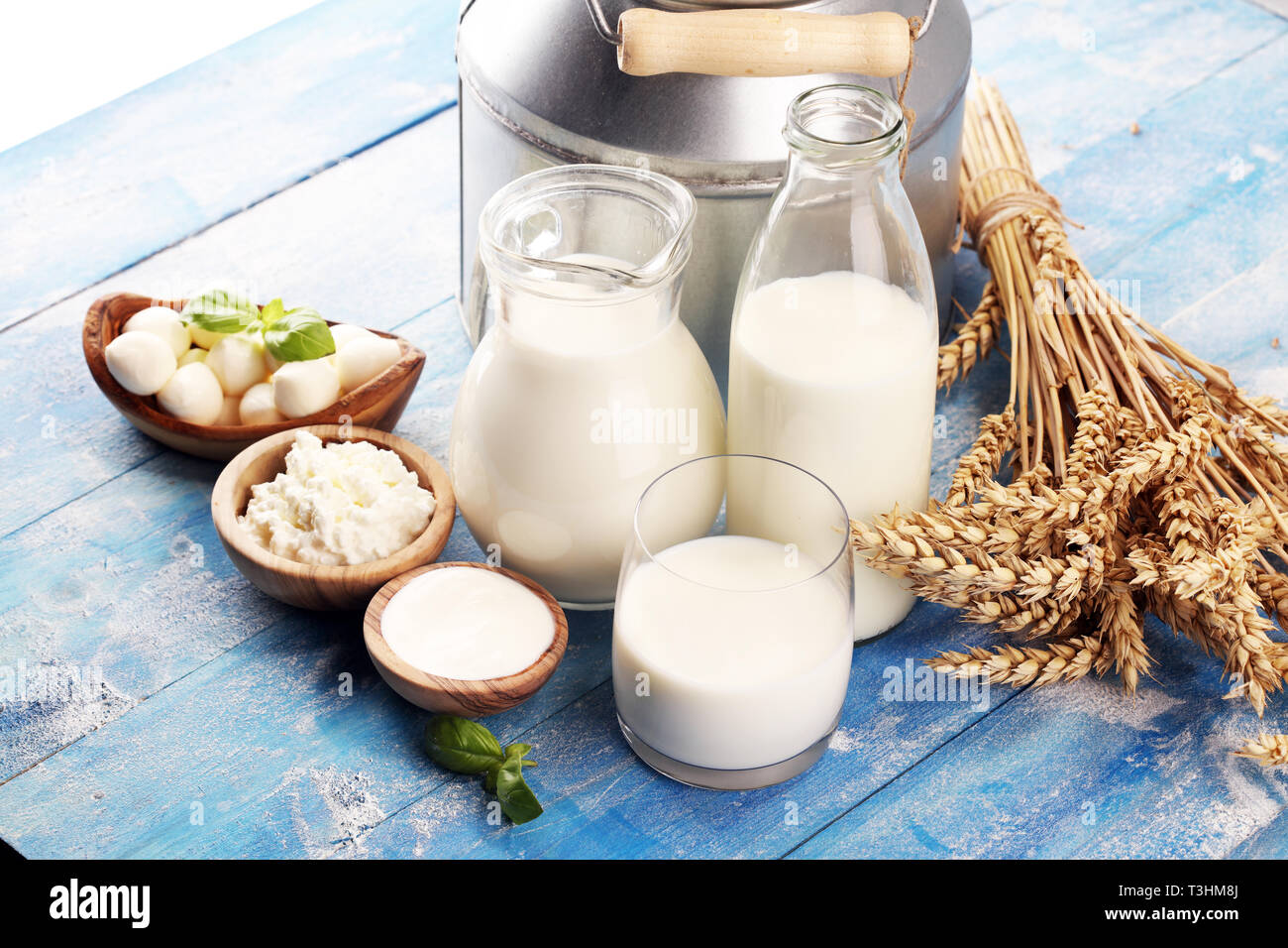 milk products - tasty healthy dairy products on a table on: sour cream in a white bowl, cottage cheese bowl, cream in a a bank and milk jar, glass bot Stock Photo
