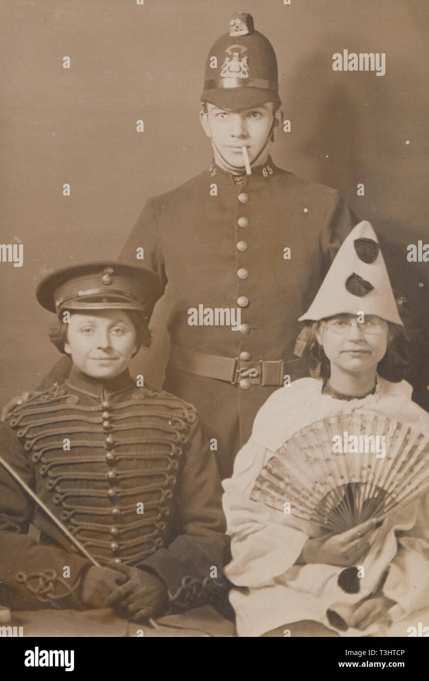 Vintage Edwardian Photographic Postcard Showing Three People Dressed Up in Theatrical Costumes. Soldier, Policeman and Pierrot Stock Photo
