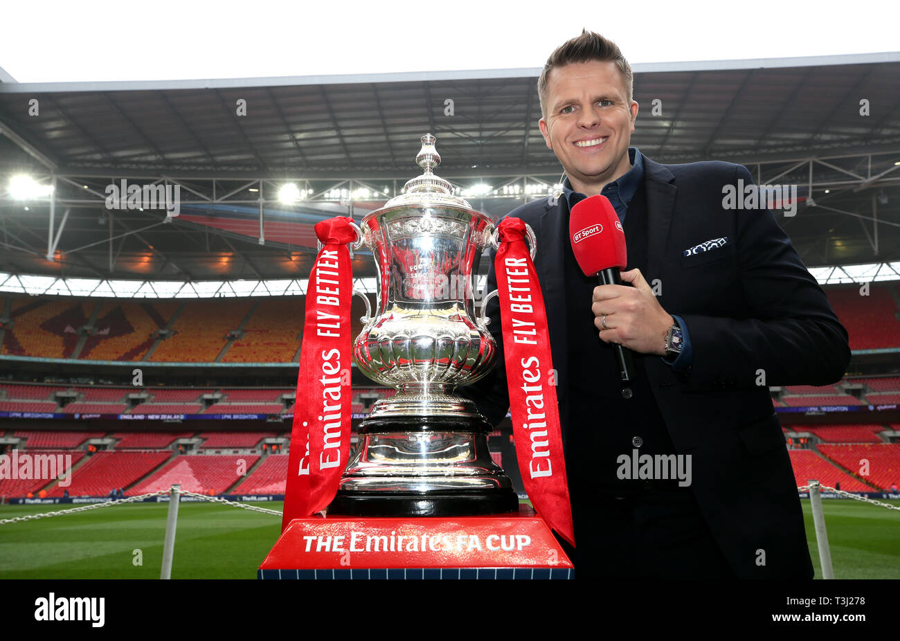 TV presenter Jake Humphrey poses for a photo next to the FA Cup trophy before the FA Cup semi final match at Wembley Stadium, London Stock Photo