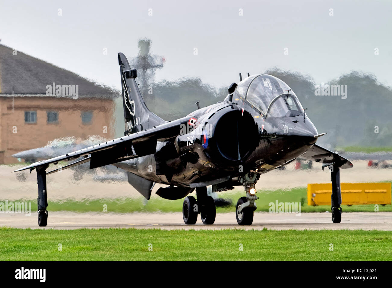 A British Aerospace Harrier T.8 -Serial No. ZB603/724 of No.899 NAS, Royal Navy Fleet Air Arm taxis towards the runway at RNAS Yeovilton, Somerset, UK Stock Photo