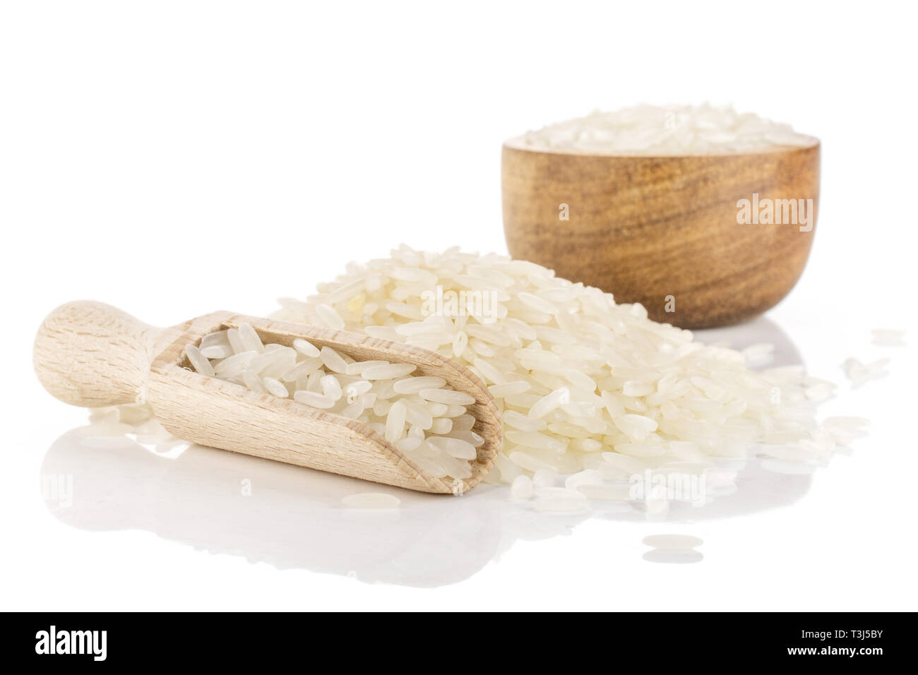 Lot of whole raw white jasmine rice grains in a wooden bowl isolated on