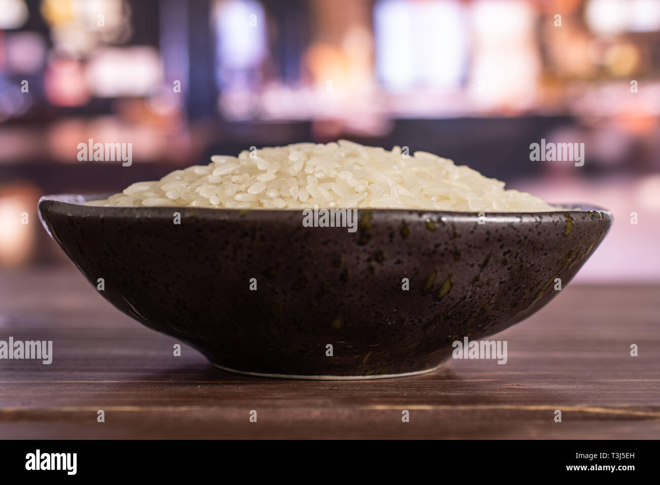 Lot of whole white jasmine rice grains on grey ceramic plate in a