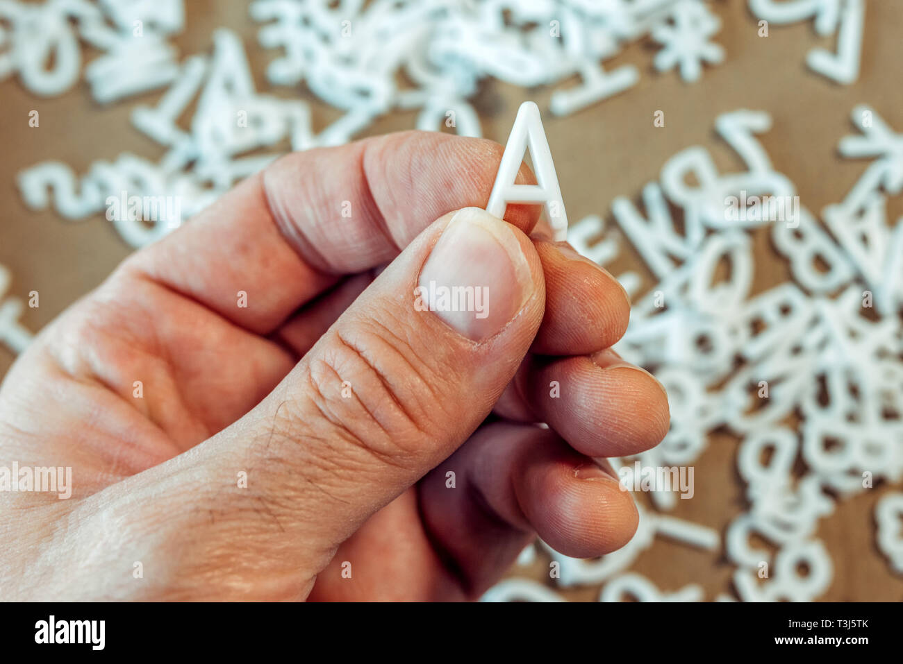 Literacy concept, male hand holding letter A Stock Photo Alamy