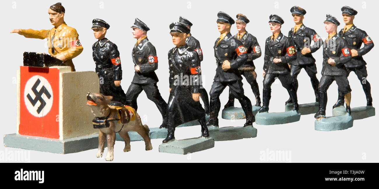 19 SS-toy figures, by the Lineol or Elastolin Companies A drum major, three drummers, three trumpeters, two marching men with service caps and overcoats, one standard bearer, one rider on horseback. Also Adolf Hitler with a moveable arm at a lectern, and a messenger dog, all from Lineol. Eight marching men (two damaged) with service caps by Elastolin. All from the 7 cm series. In addition a sentry's booth and six damaged Wehrmacht and foreign figures. historic, historical, people, 1930s, 1930s, 20th century, toy, toys, object, objects, stills, clipping, clippings, cut out, , Editorial-Use-Only Stock Photo