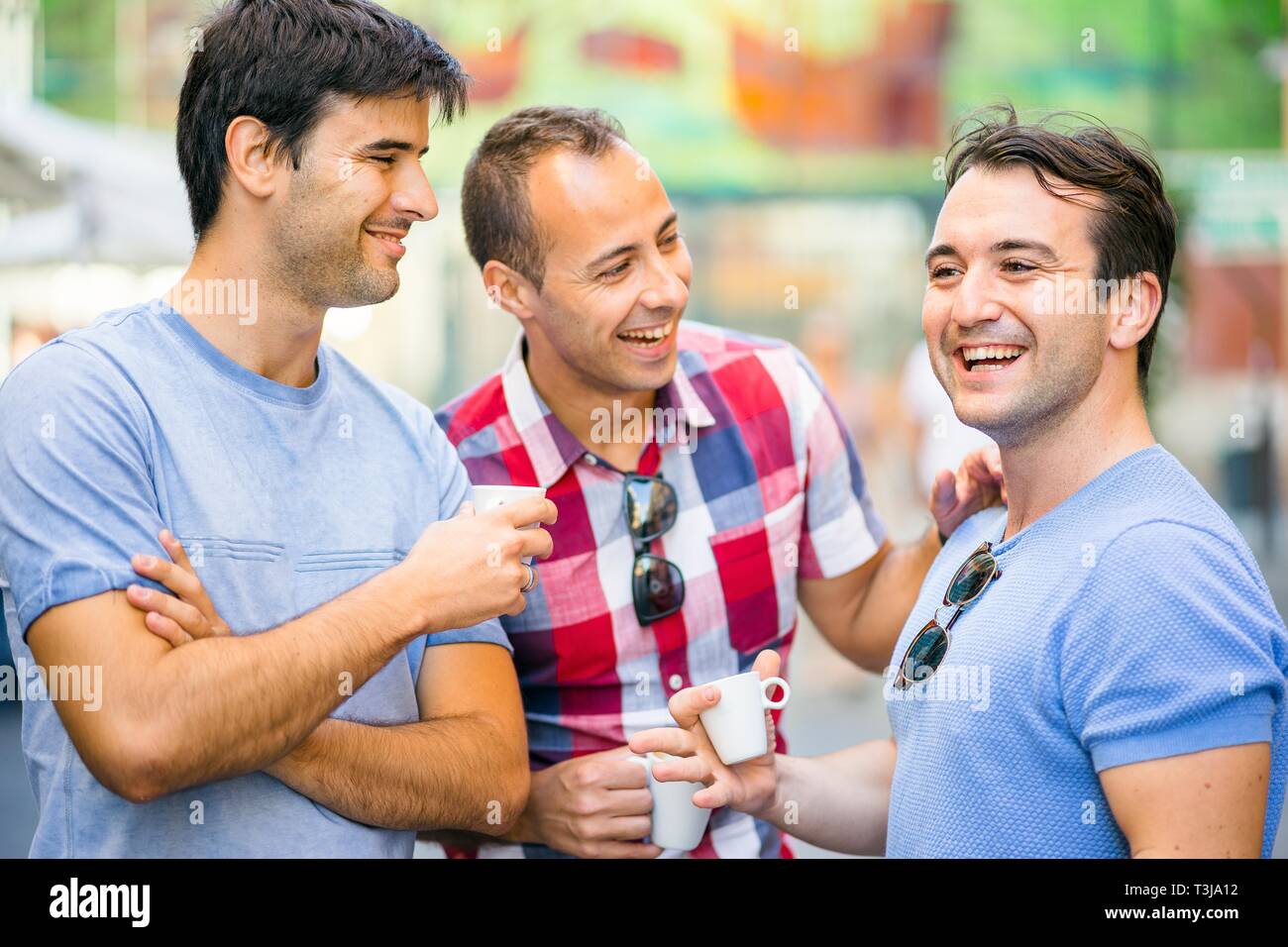 Three friends talking and having fun while drinking coffee, Portugal Stock Photo