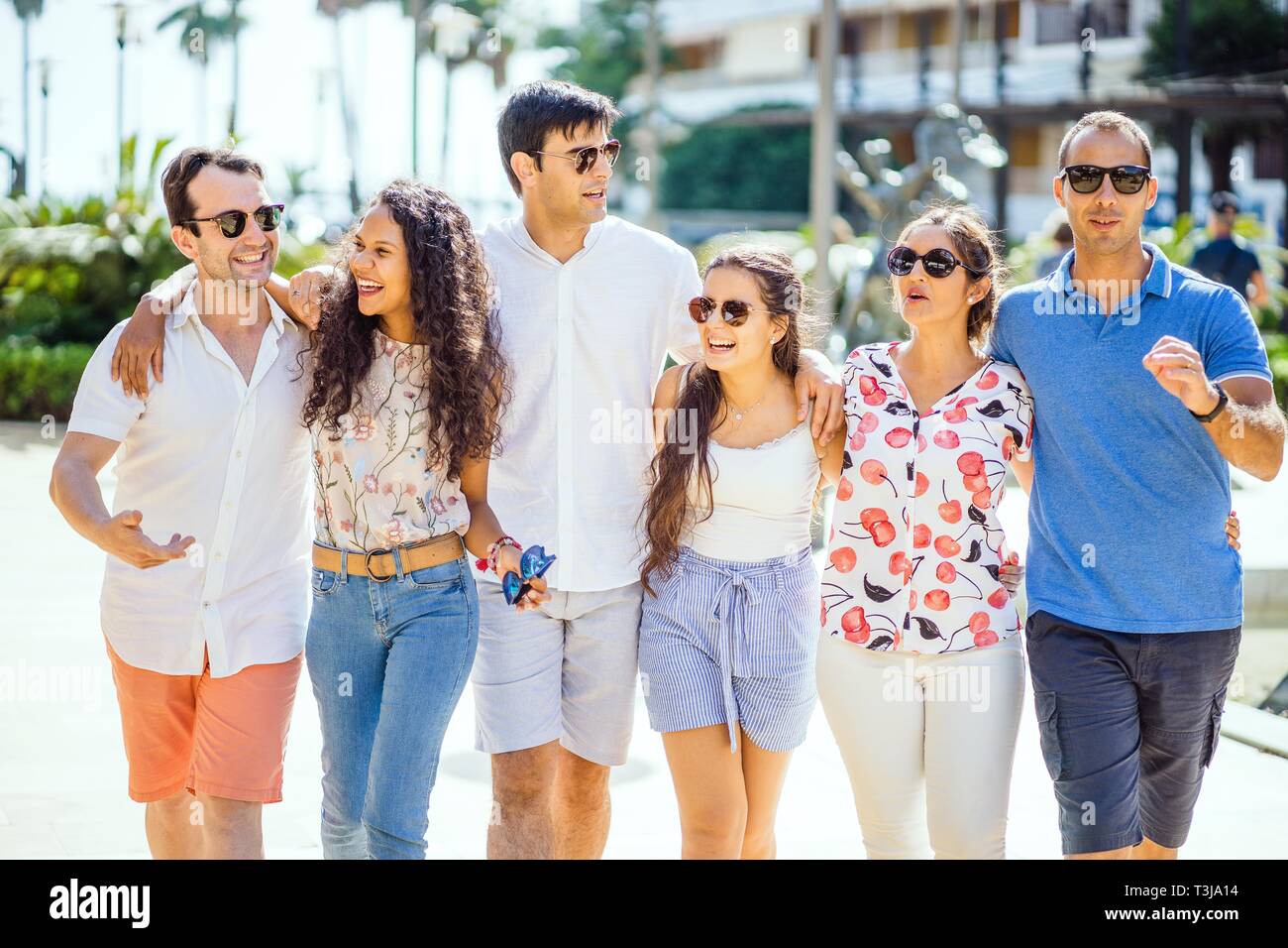 Six friends walking, taking, laughing and having fun during day time in urban setting, Portugal Stock Photo