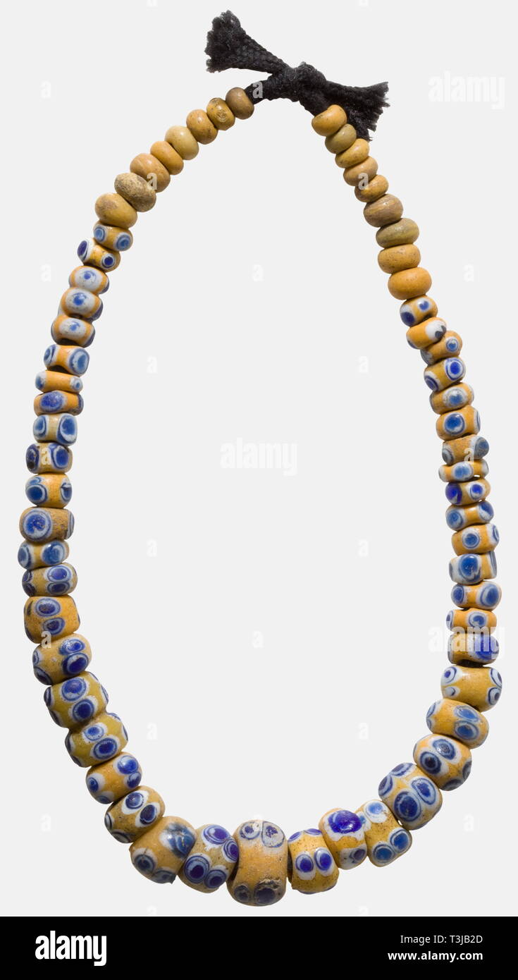 A Celtic glass eye bead necklace, 6th - 2nd century B.C. Composed of 62  yellow glass beads, 45 of them with blue-white eyes. Various shapes and  sizes. Modern cord. The beads melted