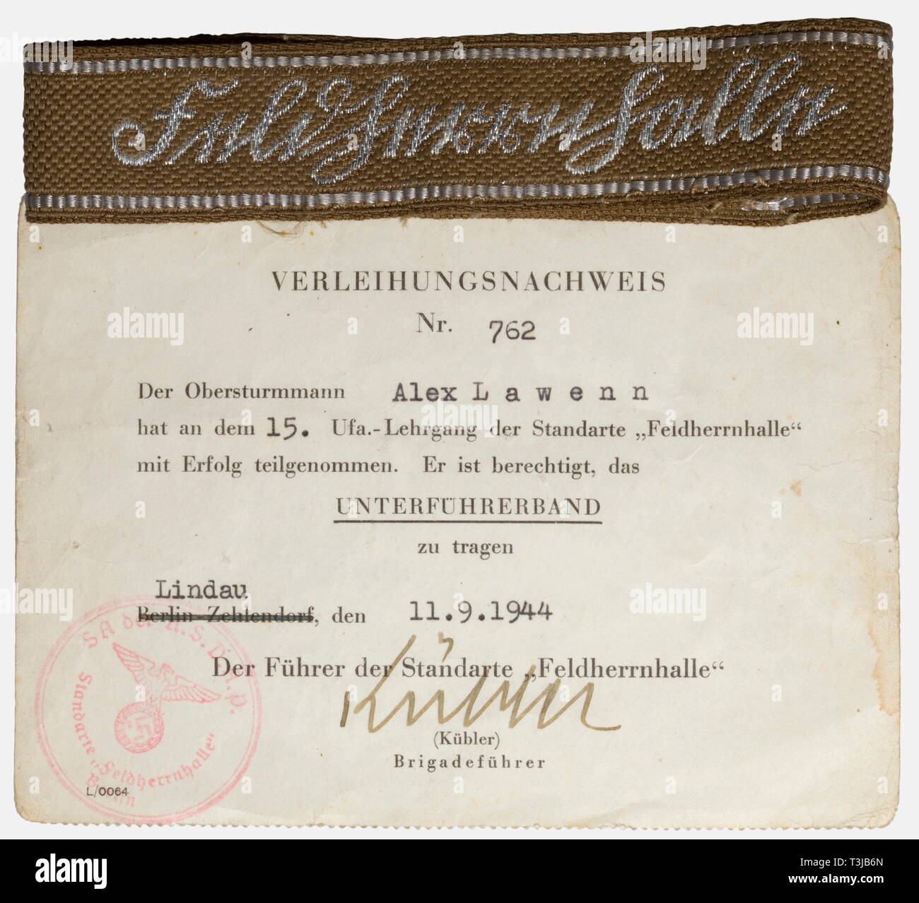 A cuff title for junior officers of the SA Standarte "Feldherrnhalle", with award certificate Cuff title with silver-woven name designation in Sütterlin script (so-called "flatwire") and borders of silver-grey artificial silk. Length about 41 cm. Included is the award certificate, Nr. 762 dated 11 September 1944 with original ink signature of Brigadeführer Kübler. historic, historical, 1930s, 20th century, storm battalion, stormtroopers, armed and uniformed branch of the NSDAP, organisation, organization, organizations, organisations, NS, National Socialism, Nazism, Third R, Editorial-Use-Only Stock Photo