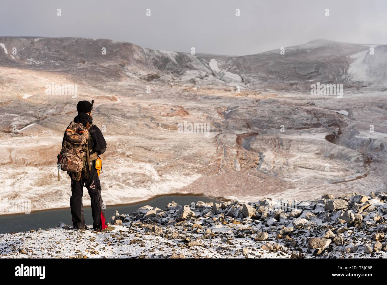 Tourist guide with rifle on the lookout for polar bears, Snaddvika, North Austland, Spitsbergen archipelago, Svalbard and Jan Mayen, Norway Stock Photo