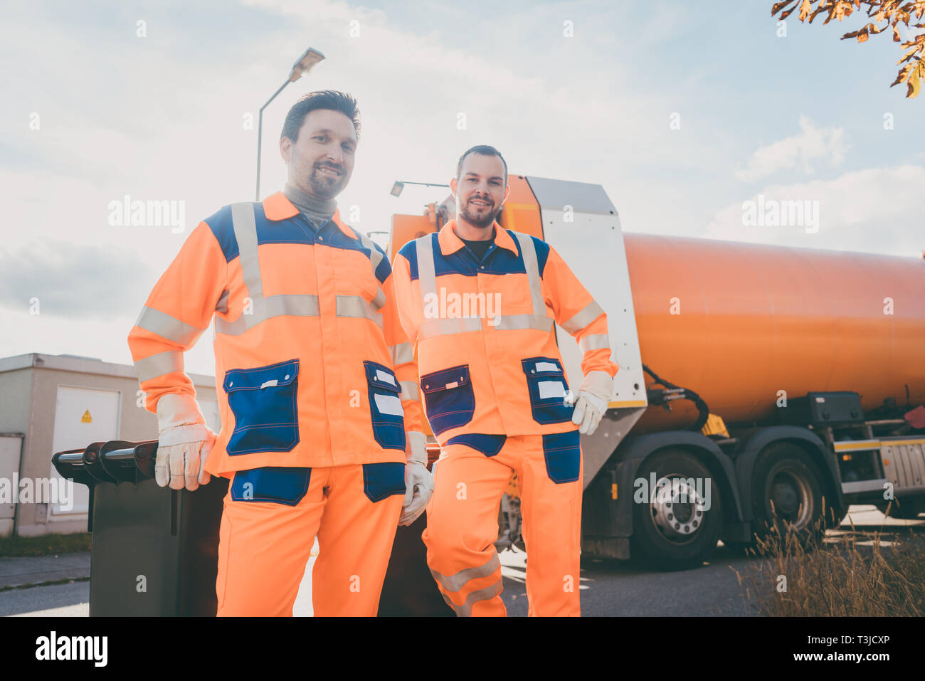 Two garbage removal service workers having short break Stock Photo