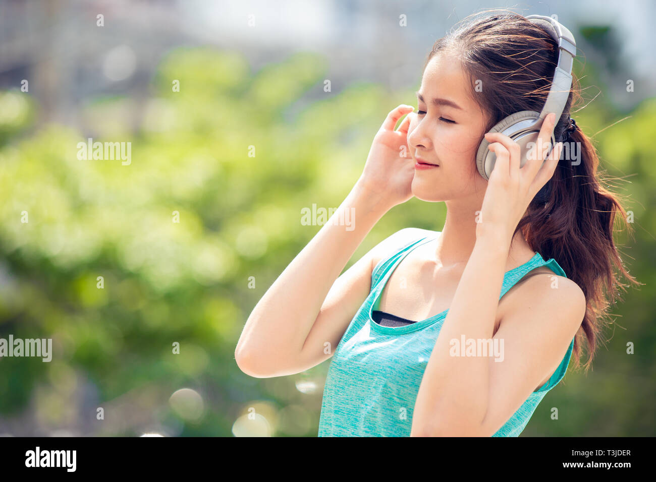 teen with wireless headphones smiling enjoy music outdoor Stock Photo