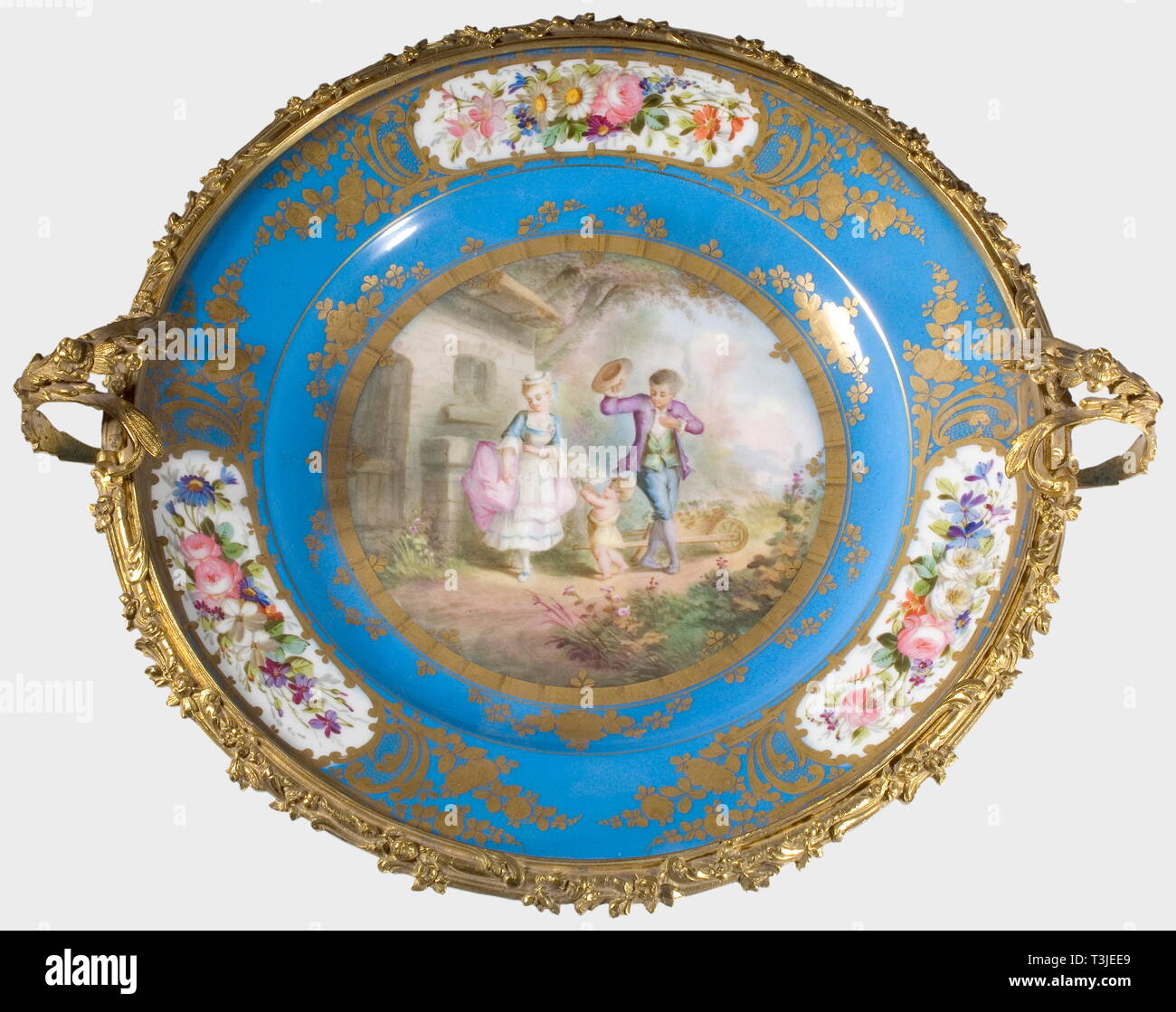 A large porcelain dish, Sèvres Factory, 19th century Sèvres-blue glazed porcelain with a hand-painted lovers' scene in the centre, the border has gilt and etched leafy vines and three cartouches with hand painted floral decoration. A reverse 'S' mark in underglaze blue on the bottom. Openwork support of gilt bronze with grape and grape leaf decoration on the four footed frame as well as floral garlands on the plate rim and the two handles. Diameter ca. 37 cm. Height ca. 20 cm. At the latest, porcelain from the French Sèvres Factory enjoyed great , Additional-Rights-Clearance-Info-Not-Available Stock Photo