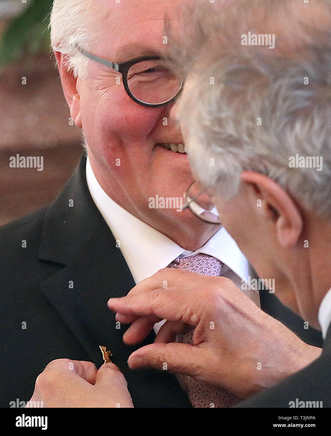 10 April 2019, Berlin: Federal President Frank-Walter Steinmeier (l) awards the outgoing head of the Berlinale, Dieter Kosslick, the Order of Merit of the Federal Republic of Germany in Bellevue Castle and receives a Berlinal Bear on his lapel in return. Photo: Wolfgang Kumm/dpa Stock Photo