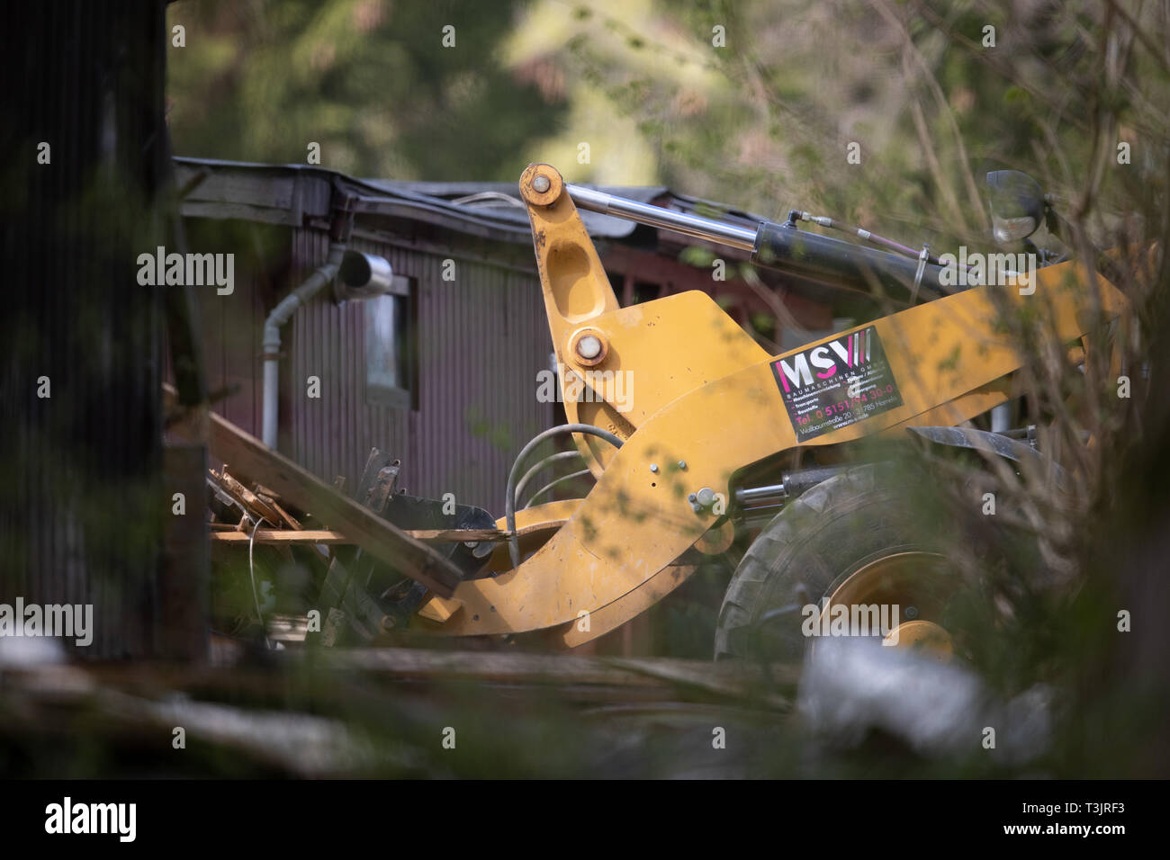 Lugde, Germany. 10th Apr, 2019. A loader pushes wooden parts of the plot of the alleged perpetrator together on the camping site Eichwald in the district Elbrinxen. The campsite operator has the crime scene torn down. Children had been abused on the campsite in the district of Lippe. Photo: Friso Gentsch/dpa Credit: dpa picture alliance/Alamy Live News Stock Photo