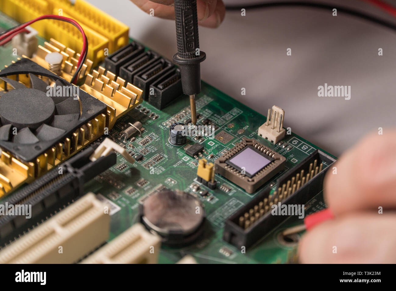 electronics technician is testing a computer chip. PC repair Stock Photo