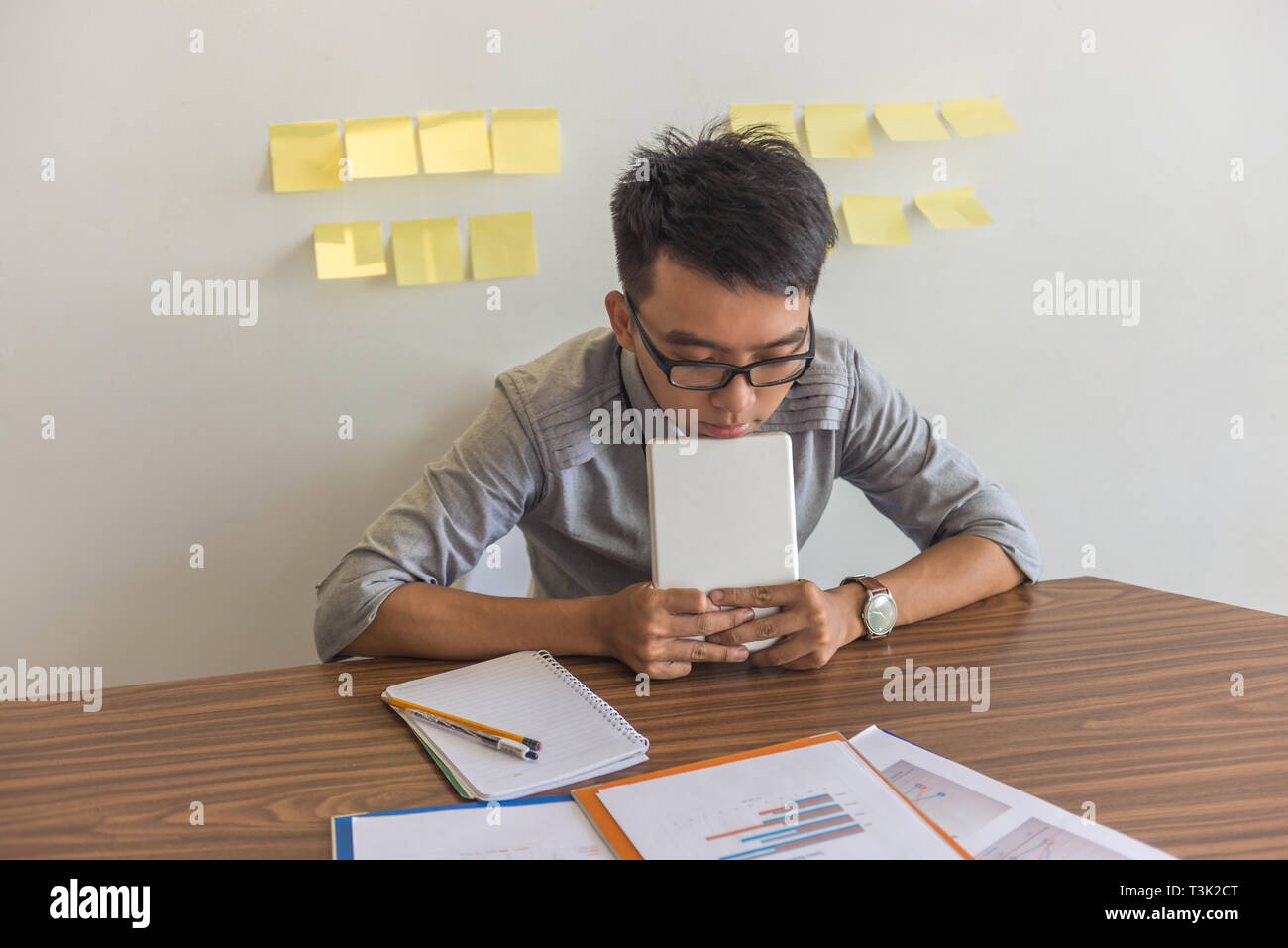 Asian office man worried about bad financial report Stock Photo