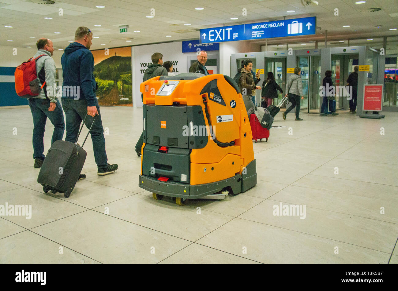 Passengers admire the autonomous cleaning machine Swingobot 2000, as the sweeping company ISS tests it at Terminal 2 on Vaclav Havel Airport Prague, R Stock Photo