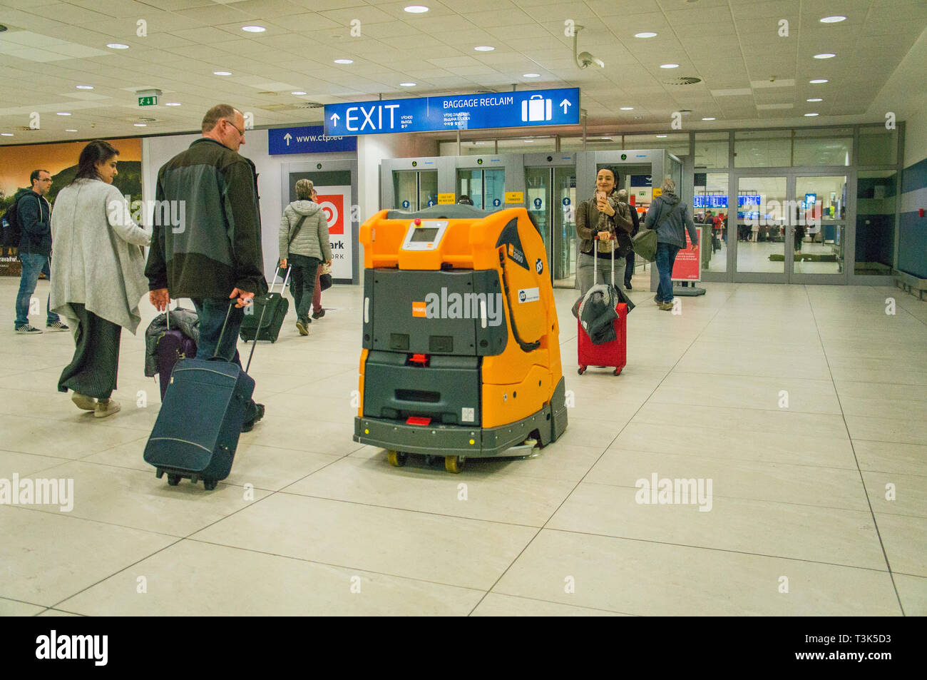 Passengers admire the autonomous cleaning machine Swingobot 2000, as the sweeping company ISS tests it at Terminal 2 on Vaclav Havel Airport Prague, R Stock Photo