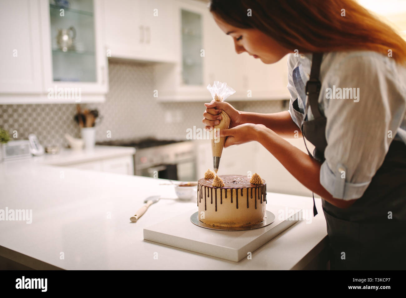 Woman Pastry Chef Decorating Chocolate Cake In The Kitchen Female