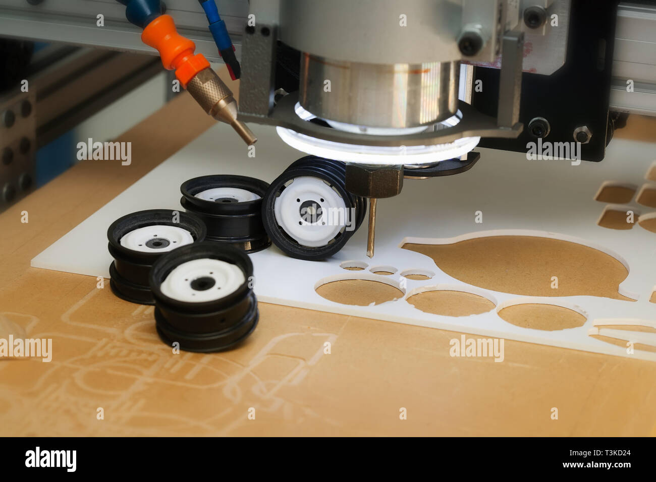 CNC desktop router machine with drill bit used to create prototype wheel designs using ABS plastic. Stock Photo