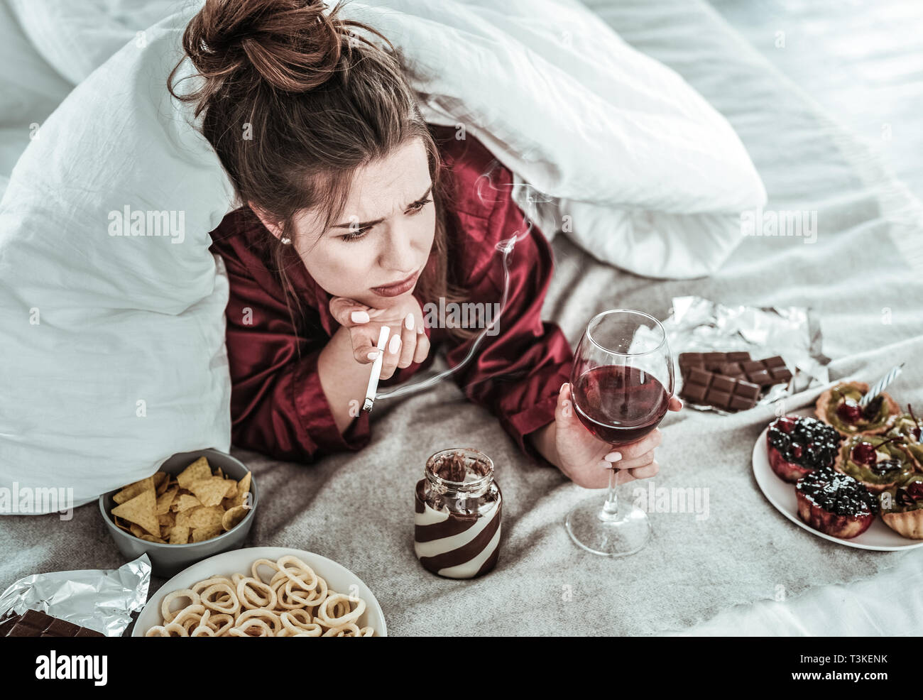 Woman performing bad habits while being depressed Stock Photo
