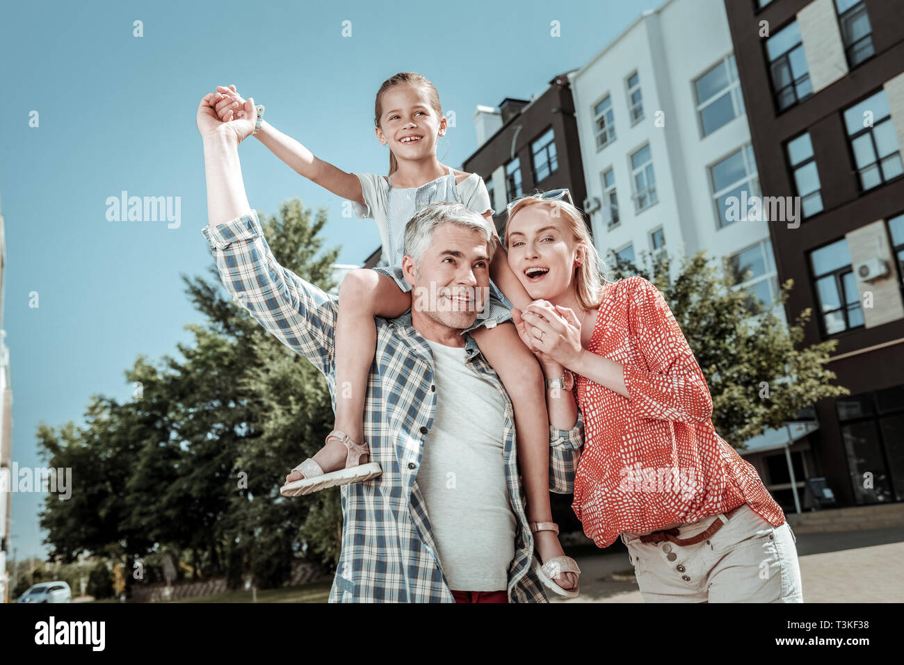 Positive delighted girl being carried by her dad Stock Photo