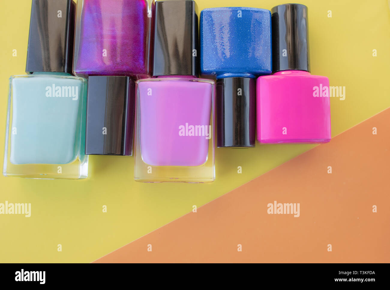 Bottles of nail polish. A group of bright nail polishes on a colored ...