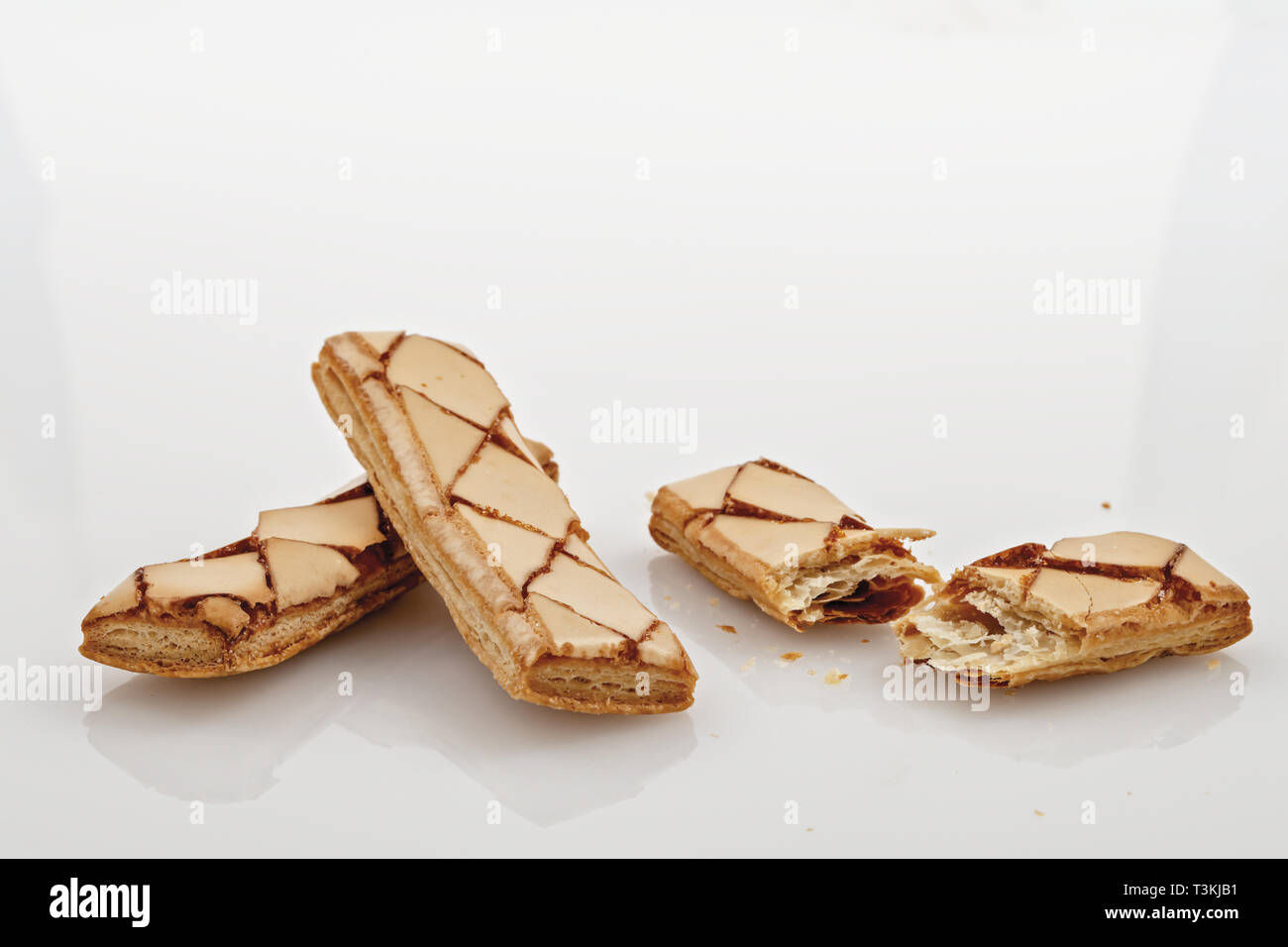 biscotti di pasta sfoglia uno rotto sfondo bianco Stock Photo