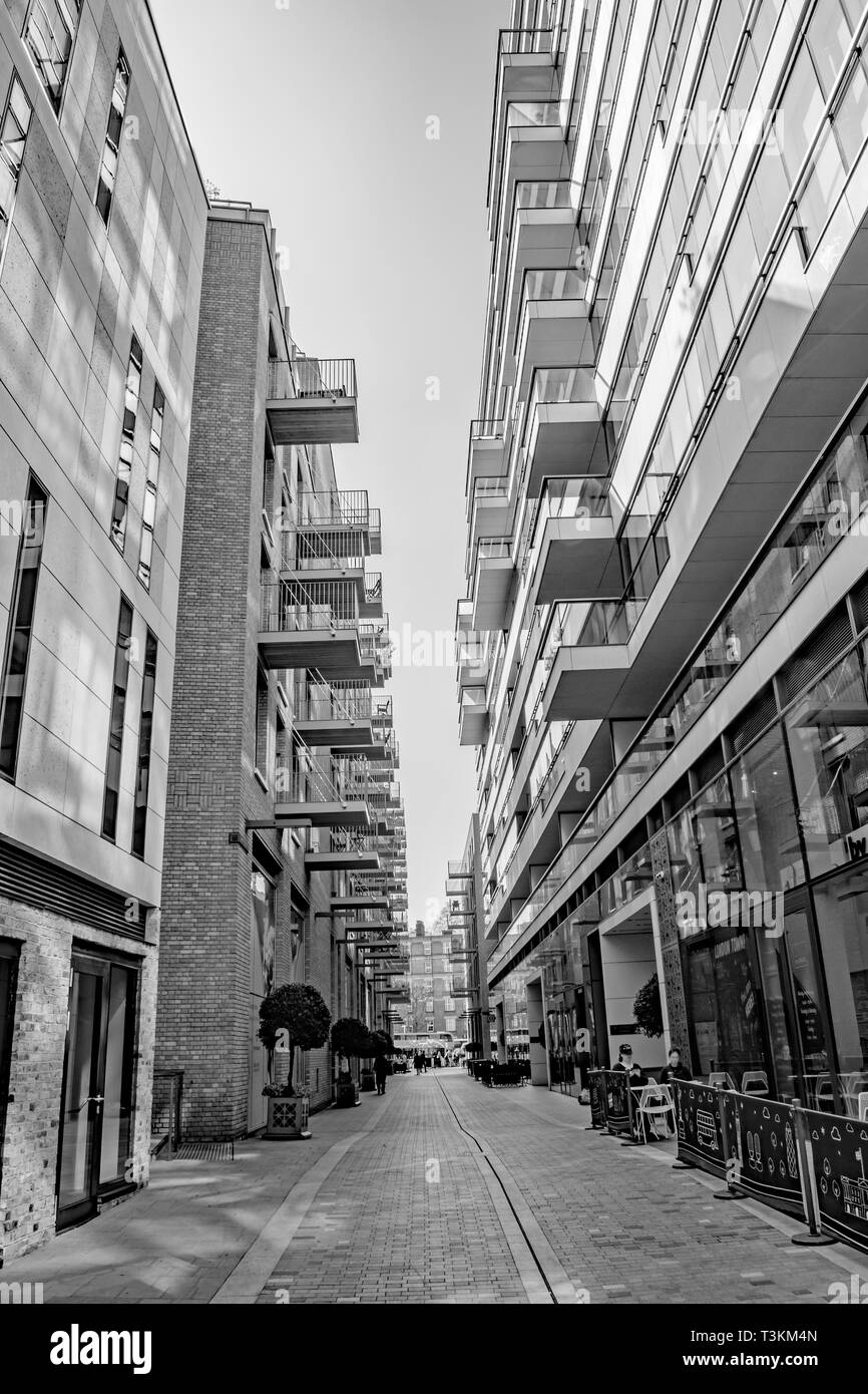 A black and white urban view of expensive residential apartment balconies in London City, with plant pot streets and cafe's Stock Photo
