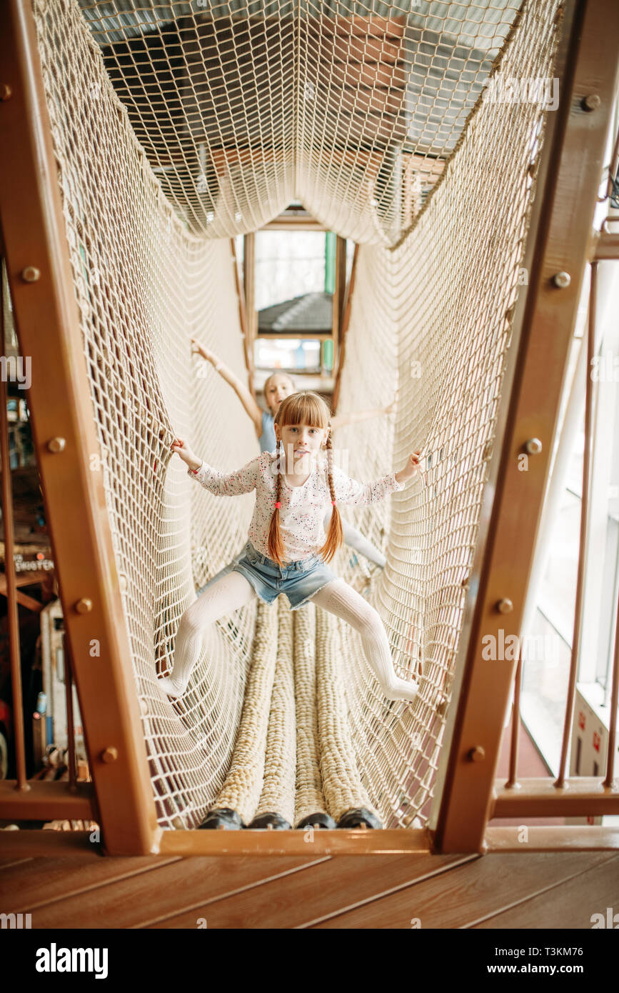 Two girls plays in rope net, children game center Stock Photo - Alamy