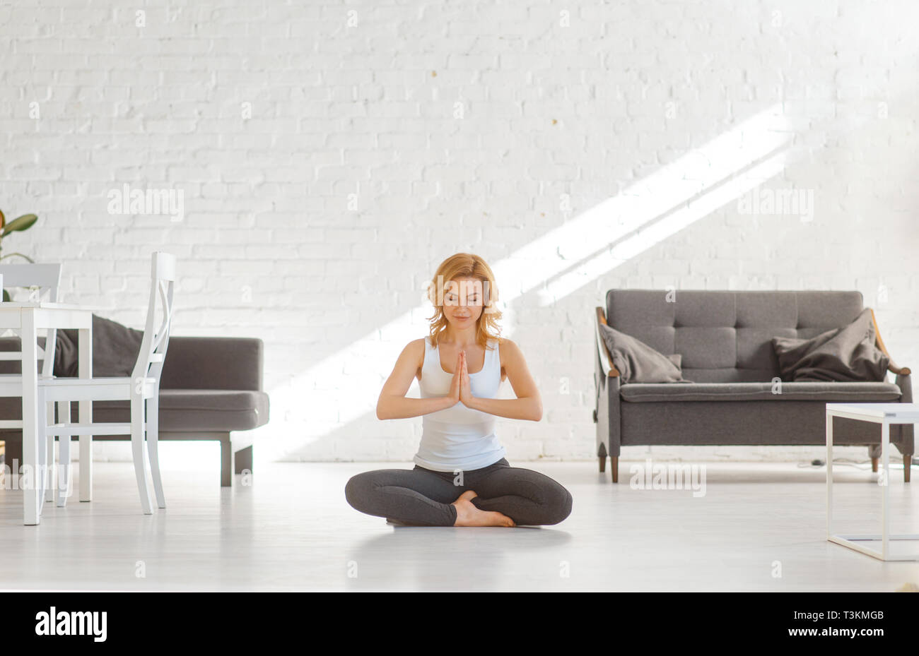 Yuong woman sitting on the floor in yoga pose Stock Photo - Alamy