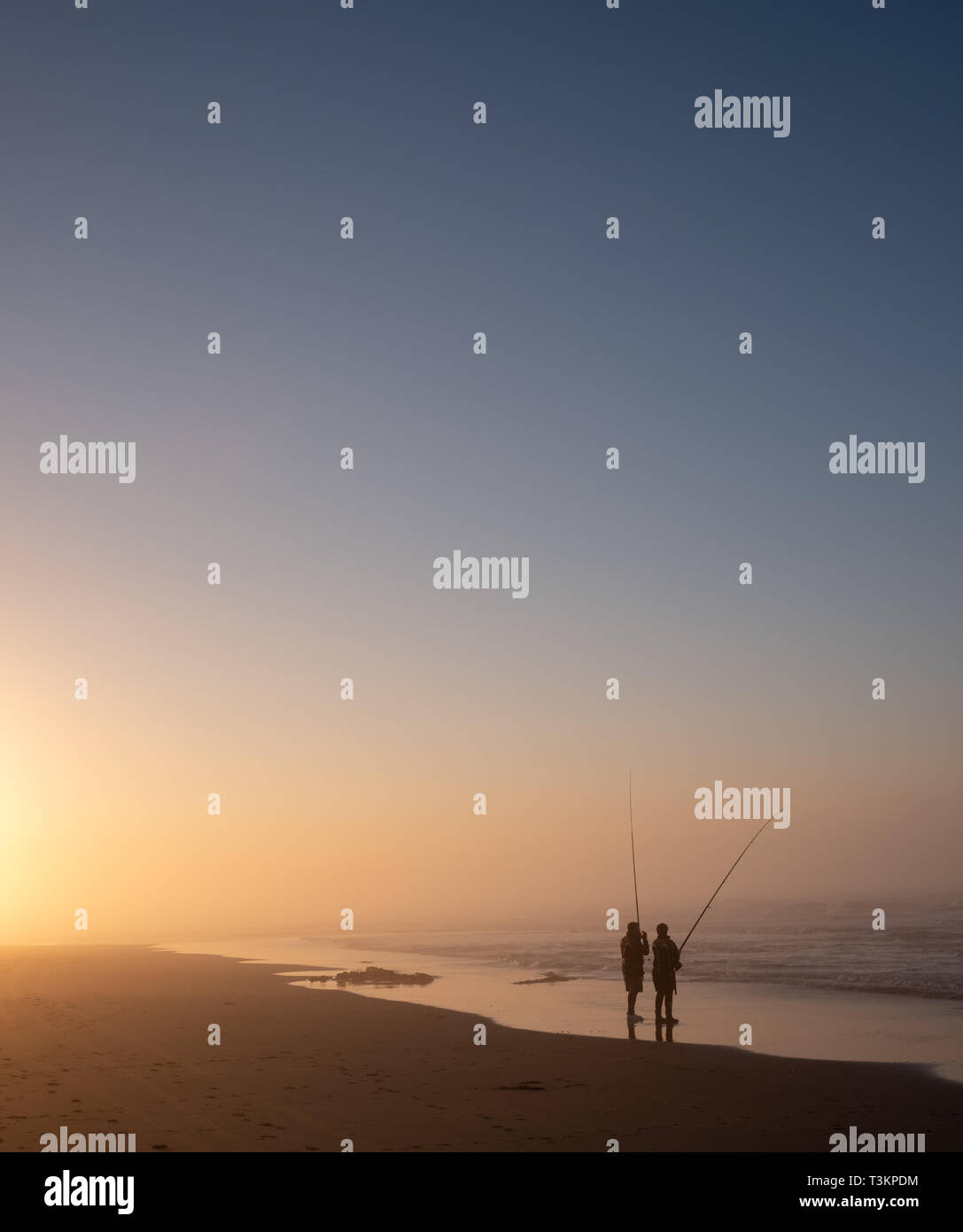 Morgan Bay beach at sunset with people fishing in silhouette, Wild Coast, Eastern Cape, South Africa. Stock Photo