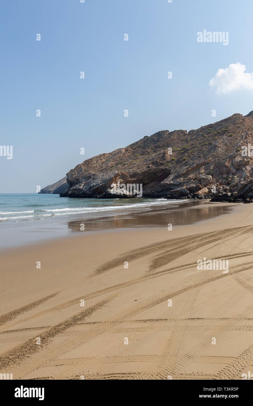 Empty Yiti Beach in a summer morning tire tracks on the sand near Muscat - Sultanate of Oman Stock Photo