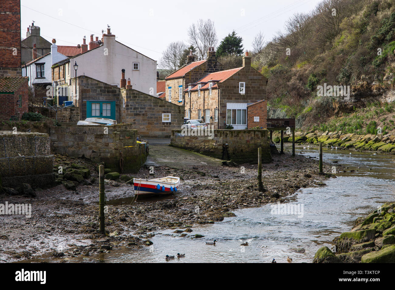 Cottages and rowing boat in Staithes Beck, Staithes, a traditional fishing village and seaside resort on the North Yorkshire coast, England UK. Stock Photo