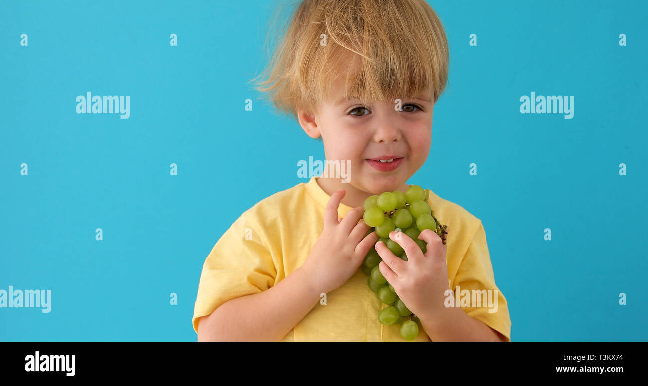 View of Healthy eating concept with child eating grapes Stock Photo - Alamy