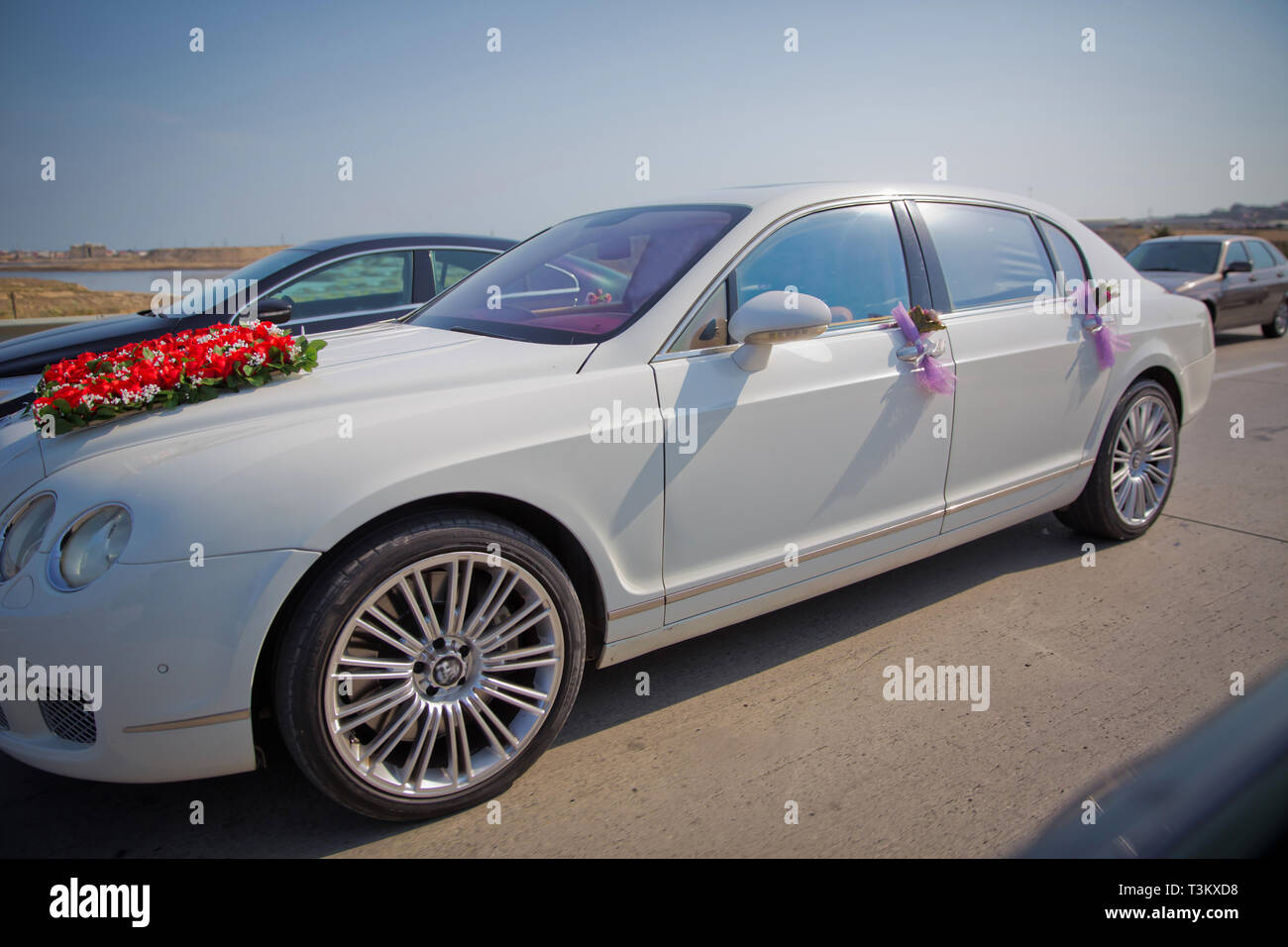 Closeup image of wedding car decoration with red and white flowers