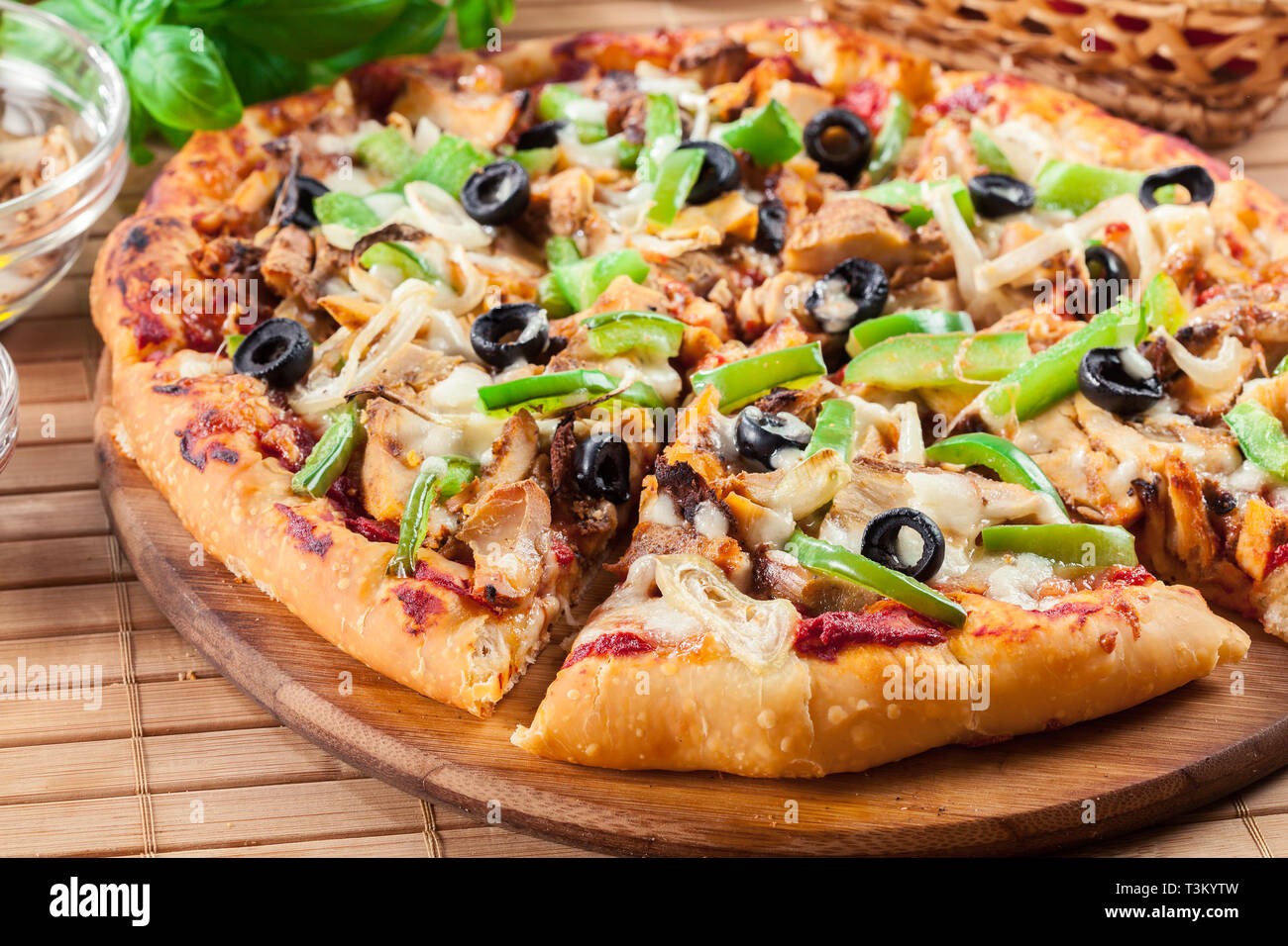 Spicy pizza with chicken gyros, green pepper, olives and onion on cutting  board Stock Photo - Alamy