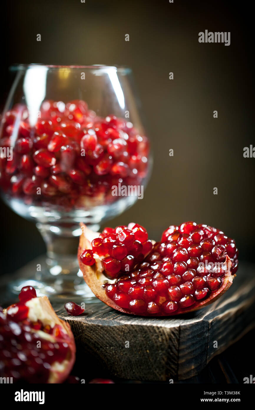 Ripe pomegranate fruit on a old black wooden vintage background. Selective focus. Stock Photo