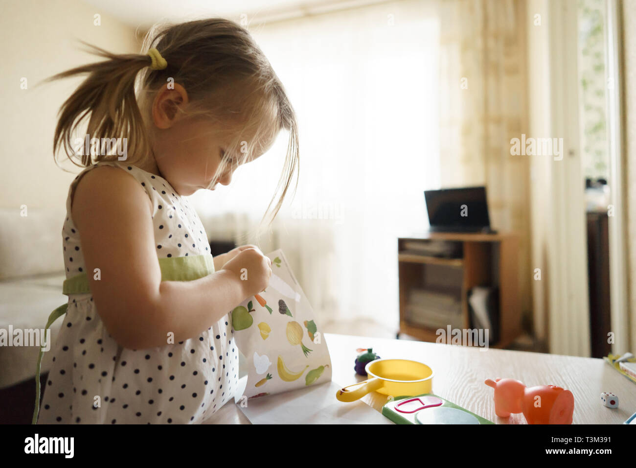 little girl playing at home with toys Stock Photo - Alamy