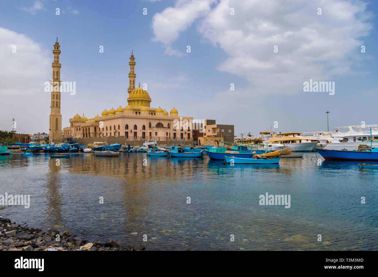 View of the Al Mina Masjid Mosque and its minarets in the city of hurghada from the old marina with its fishing boats Stock Photo