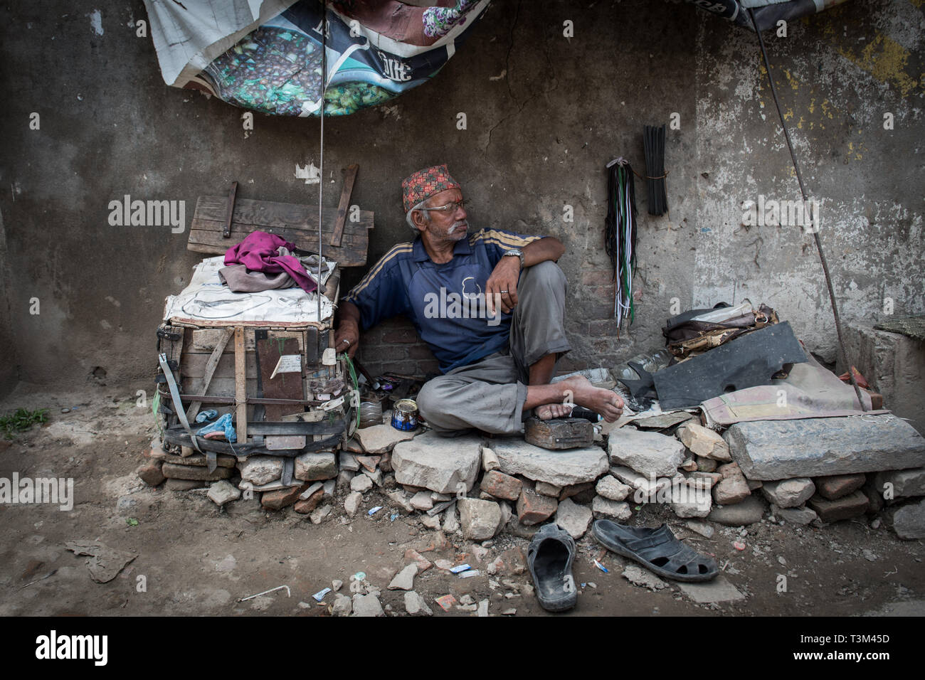 Cobbler waiting for business on the road between Patan and Kathmandu, Nepal Stock Photo