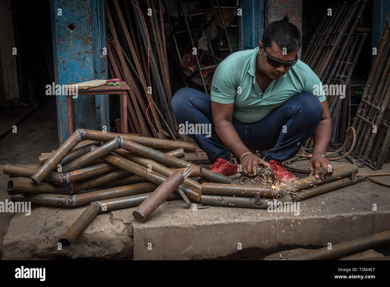 Man welding pipes in workshop, Bhaktapur, Nepal Stock Photo