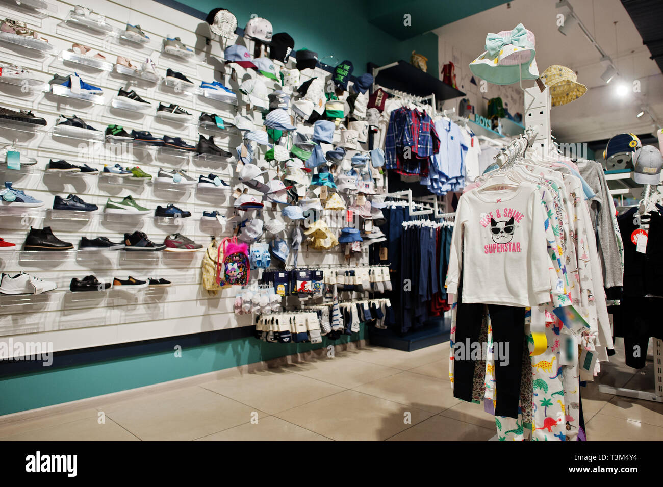 Luxury and fashionable brand new interior of kids shoes, caps and cloth store. Stock Photo