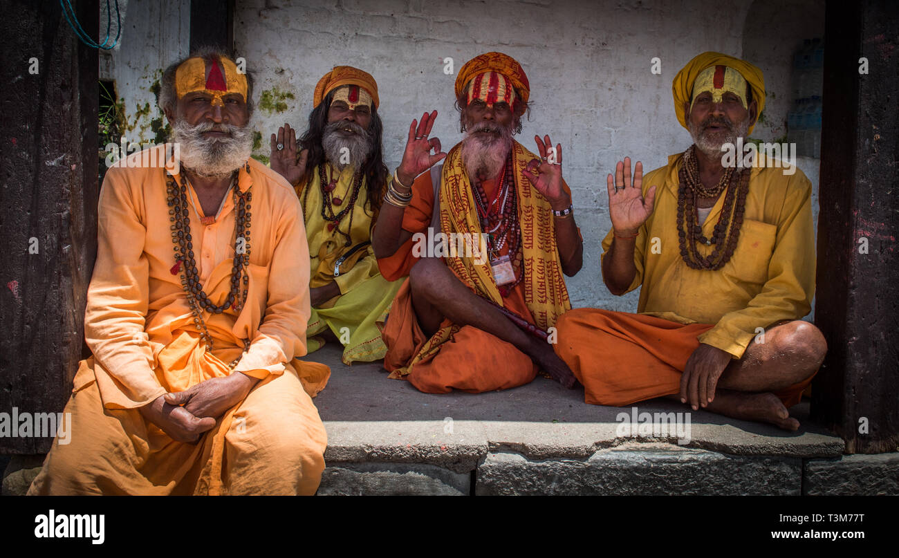 Four sadhus sitting in the shade at pashupatinath temple, Nepal Stock Photo